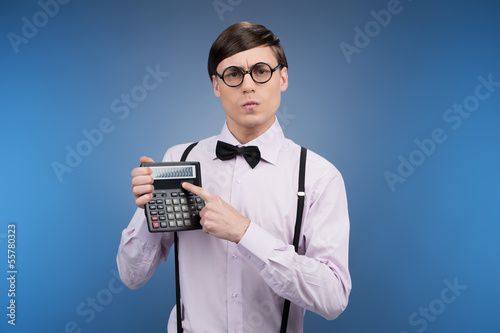 Nerd with calculator. Young nerd man holding calculator and poin photo