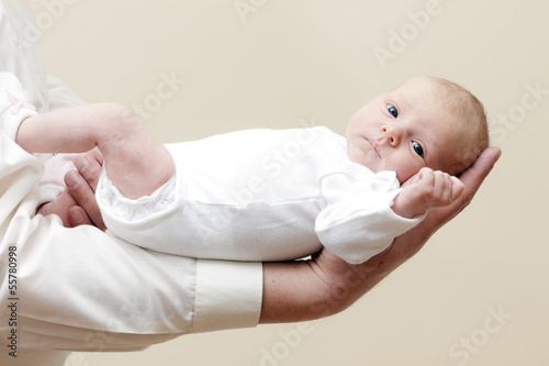 newborn baby girl lying on arm