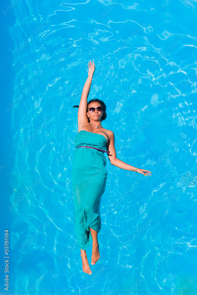 Woman floating above swimming pool