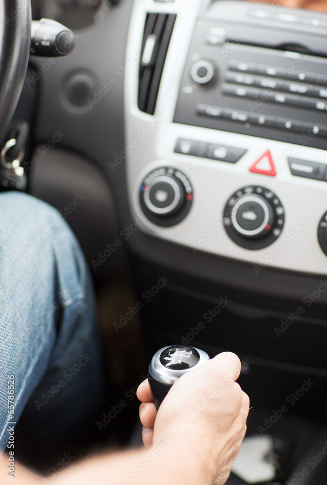 man shifting the gear on car manual gearbox