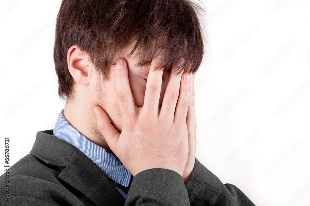 Young man holding his hands over his face Young man holding his hands over his face