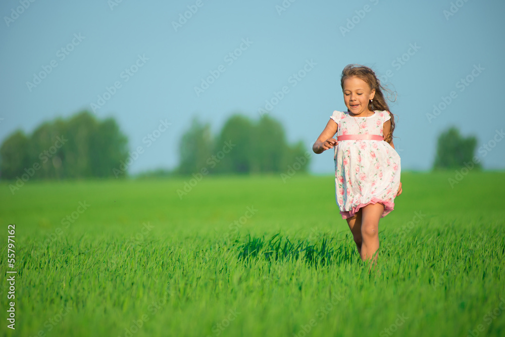 Fototapeta premium Young happy girl running at green wheat field
