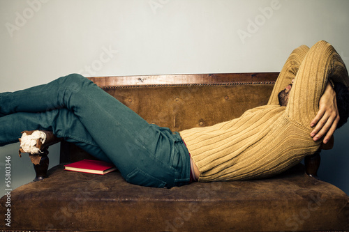 Young man sleeping on old sofa