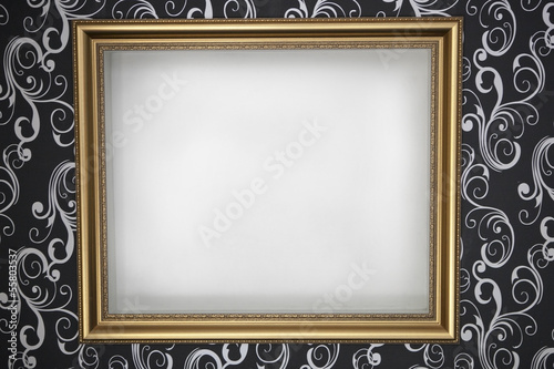 gold frame with a white background on the wall with dark wallpap