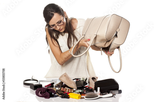 unhappy girl can not find something in her bag