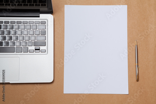 blank paper and laptop on table