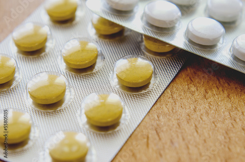 pills and tablets spilled on wooden background