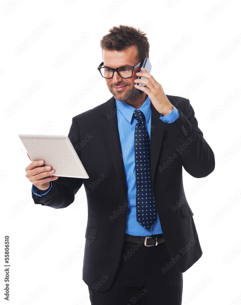 Busy businessman working on tablet and mobile phone Busy businessman working on tablet and mobile phone