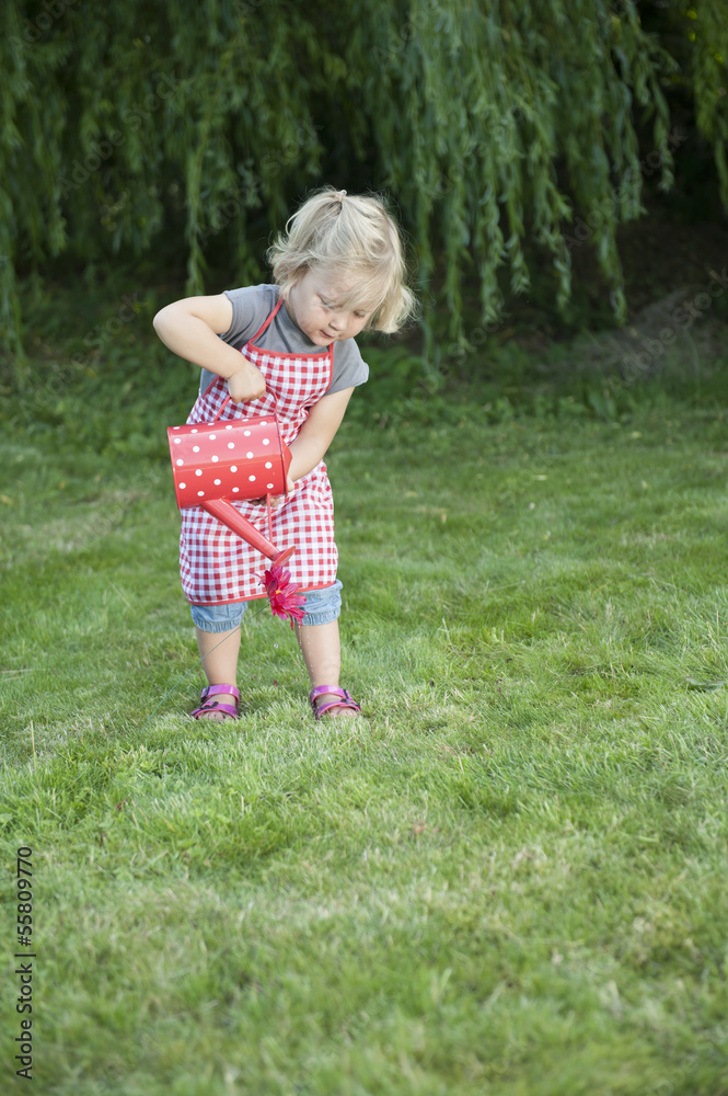 little girl with watering can in the garden little girl with watering can in the garden
