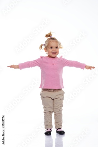 Happy little girl in pink knitted jacket