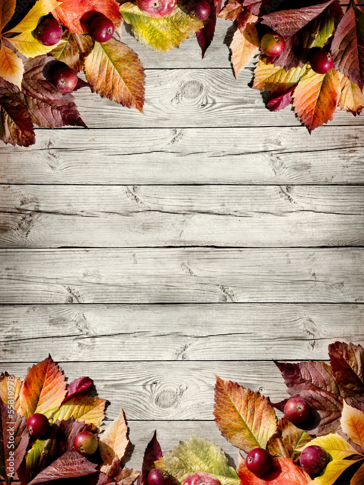 Naklejka premium Autumn border from apples and fallen leaves on old wooden table
