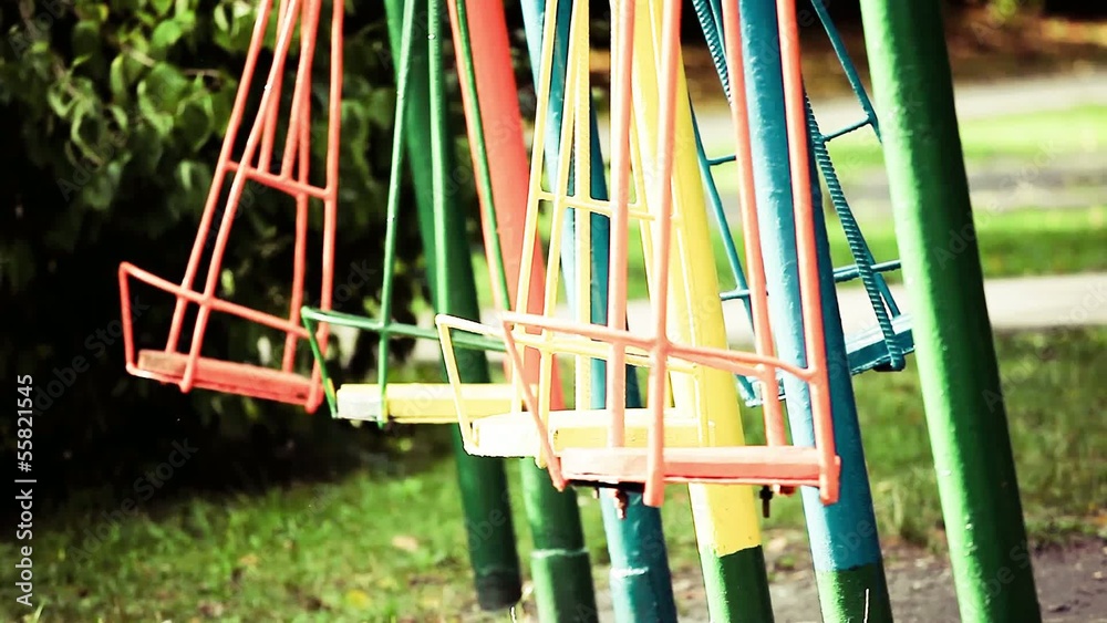 Empty chain swings on summer kids playground Empty chain swings on summer kids playground