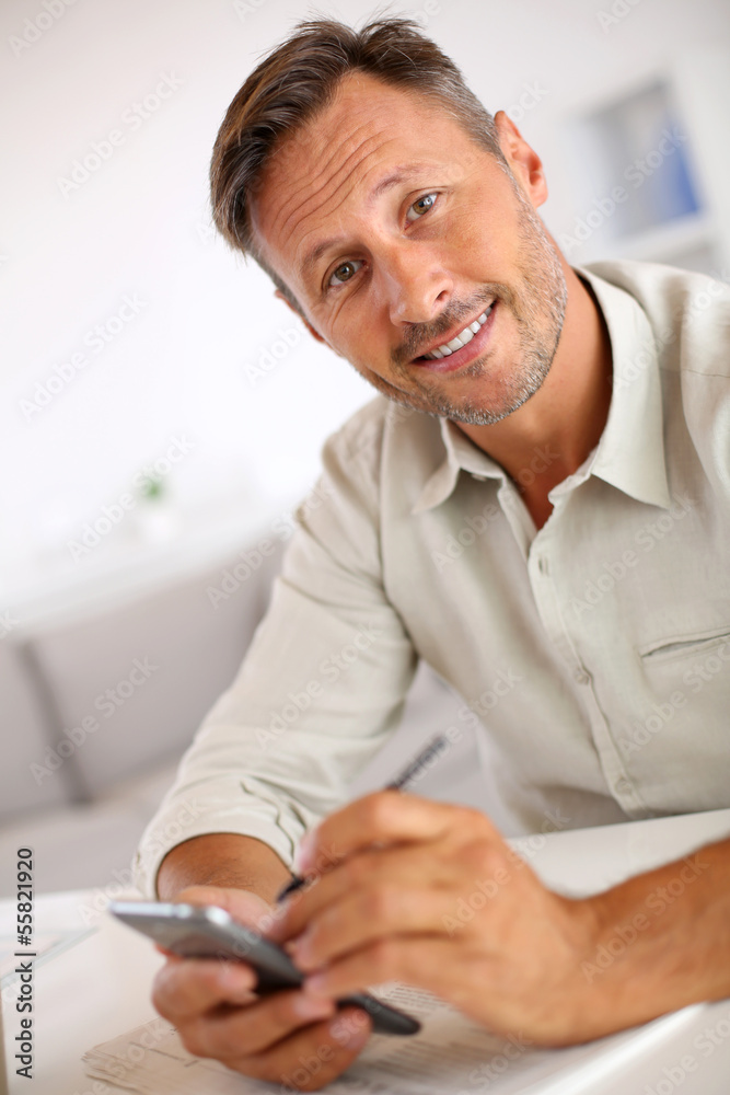 Smiling guy sending message with smartphone Smiling guy sending message with smartphone