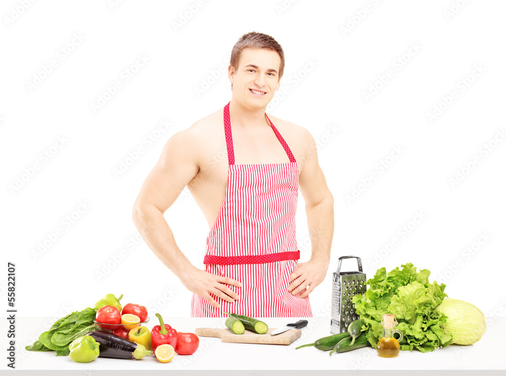Shirtless male with apron preparing salad Shirtless male with apron preparing salad