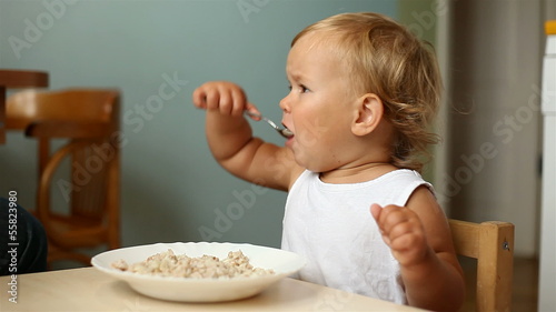 little girl eats porridge