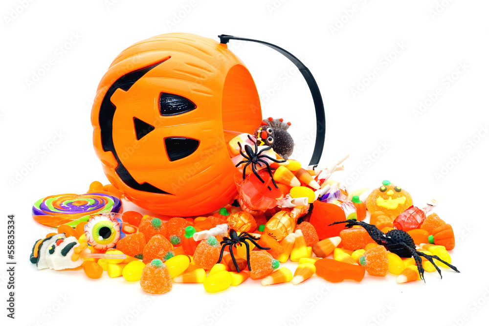 Fototapeta premium Halloween candy spilling from a Jack o Lantern holder