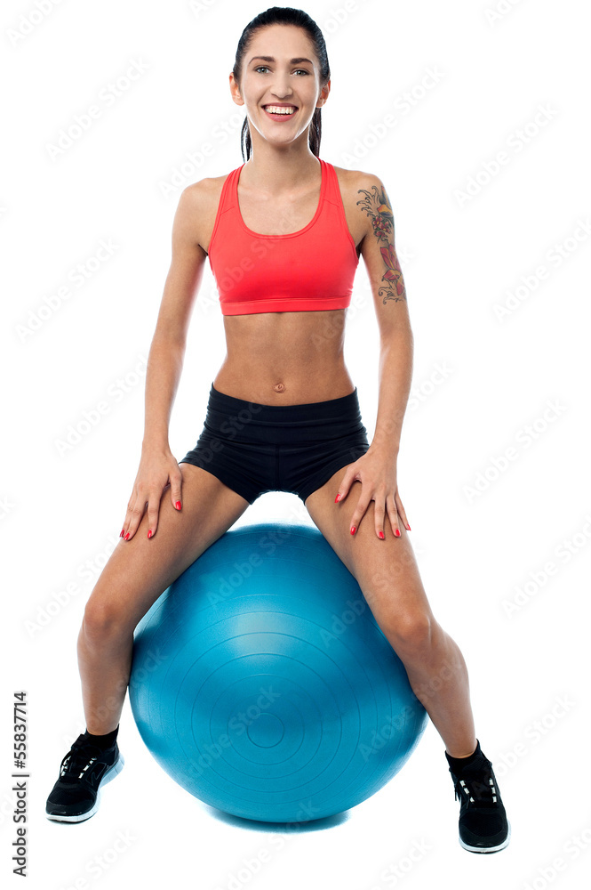 Woman in gym relaxing on pilates ball Woman in gym relaxing on pilates ball