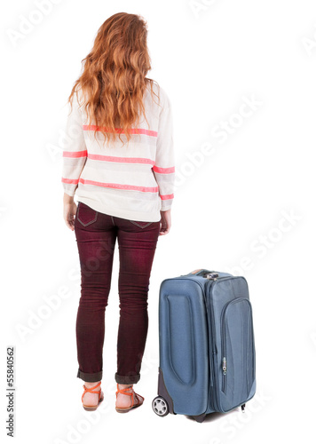 back view of walking woman with suitcase.