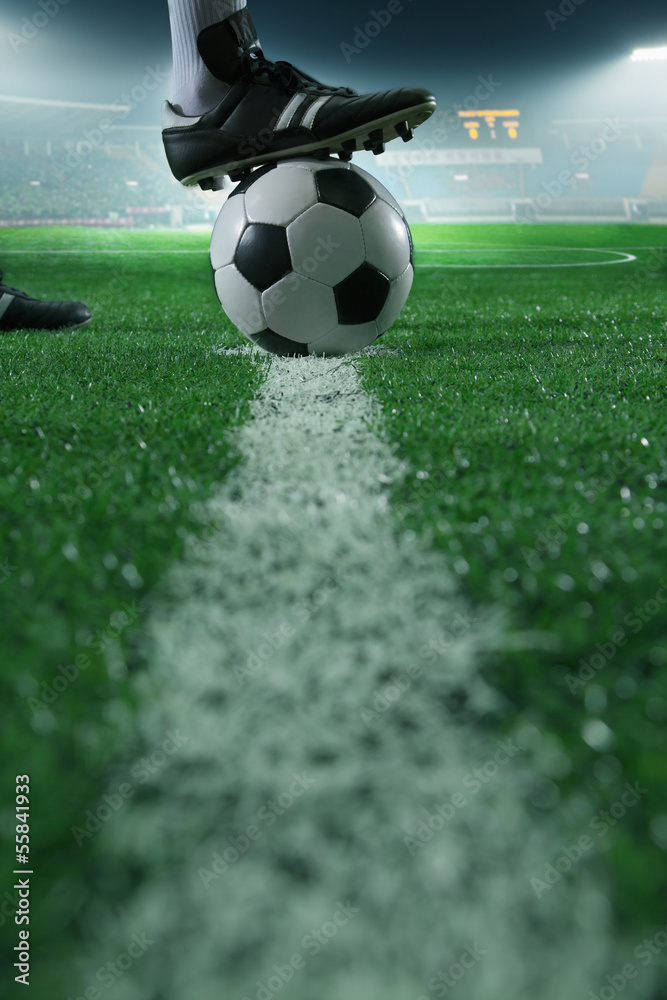 Obraz na płótnie Close up of foot on top of soccer ball on the line, side view, stadium w salonie