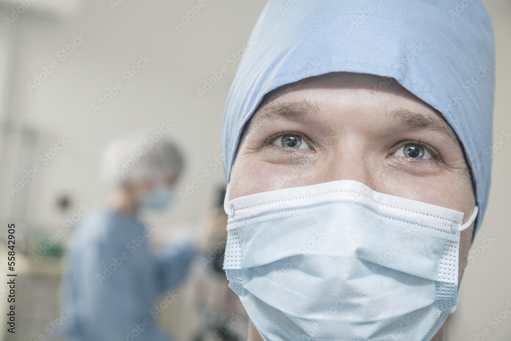 Portrait of surgeon with surgical mask and surgical cap in the operating room 