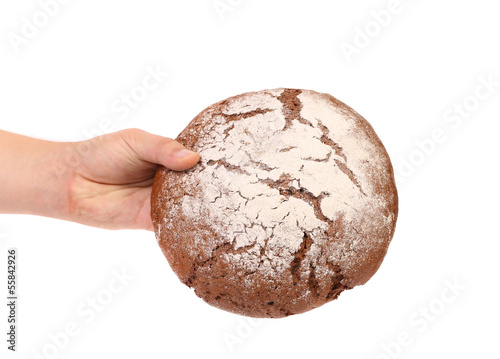 Hand holds brown round bread.