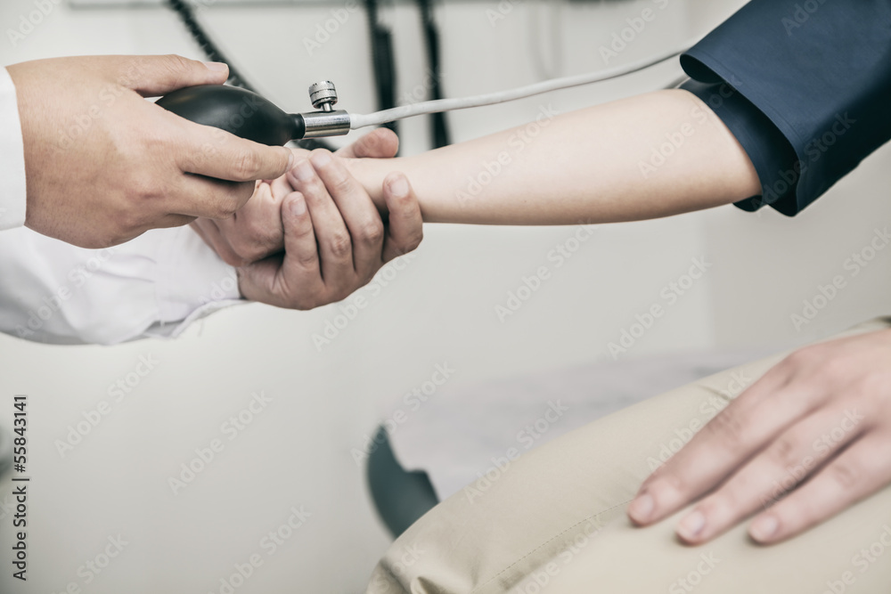 Close-up of doctor checking blood pressure on the arm