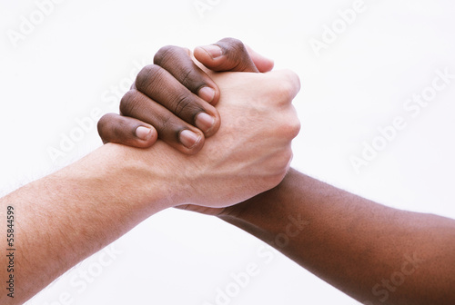 Fotografie Two young men shaking hands, close-up, studio shot