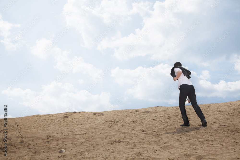 Young businessman lost and walking through the desert Young businessman lost and walking through the desert