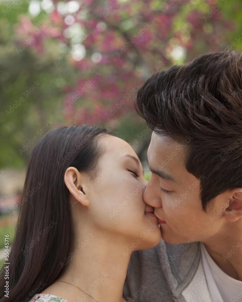 Young couple in love and kissing outdoors in the park Young couple in love and kissing outdoors in the park