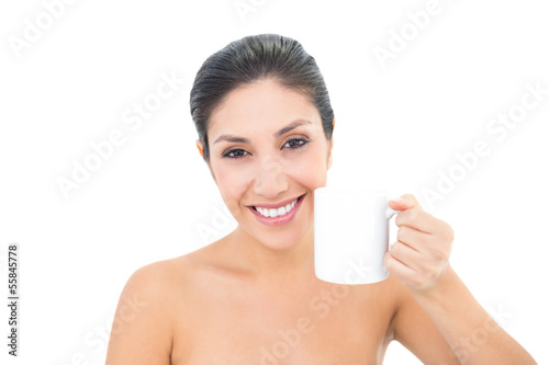 Attractive brunette holding a white mug and smiling at camera