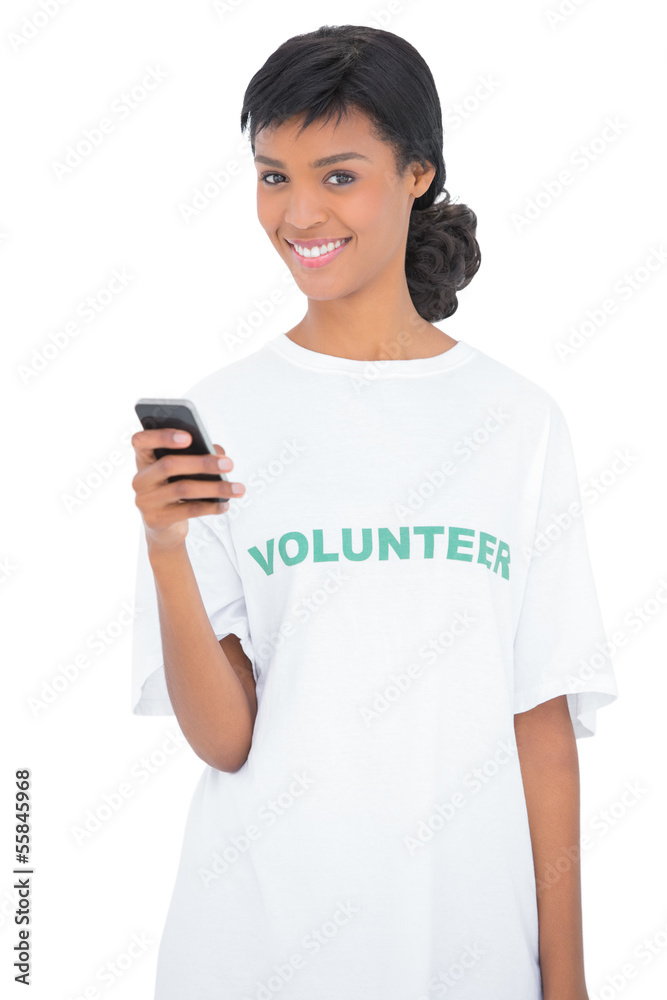 Charming black haired volunteer texting with her mobile phone Charming black haired volunteer texting with her mobile phone
