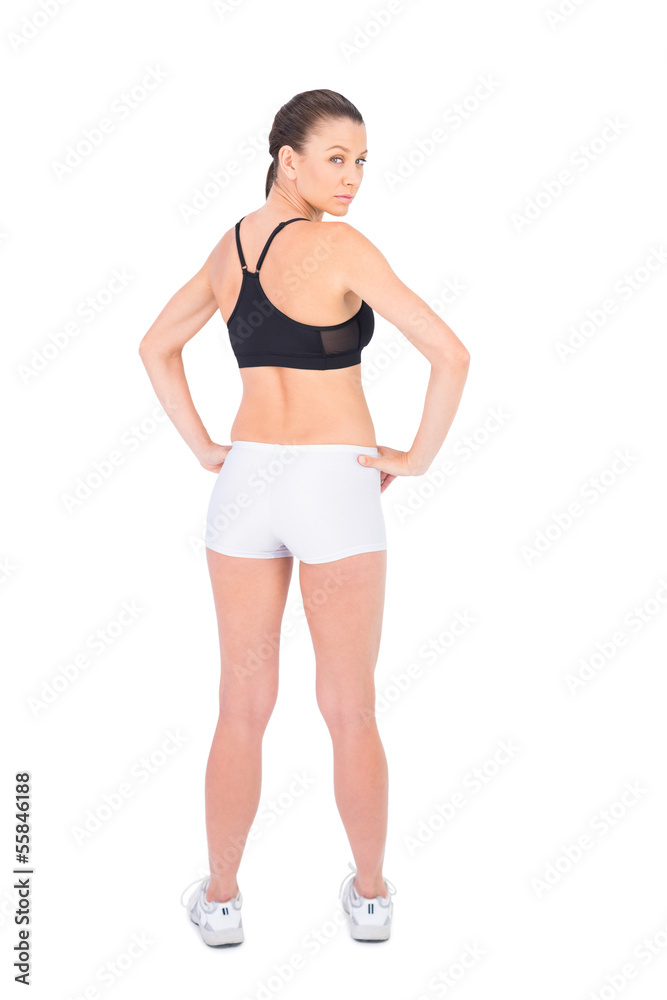 Serious woman in sportswear standing back to camera Serious woman in sportswear standing back to camera
