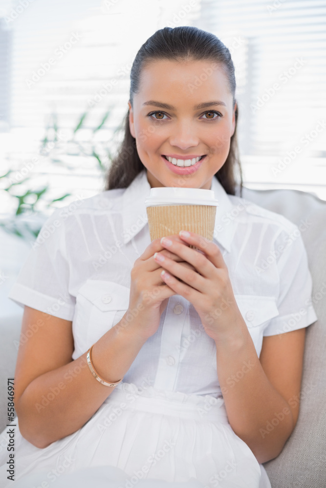 Smiling pretty woman having coffee sitting on cosy couch Smiling pretty woman having coffee sitting on cosy couch