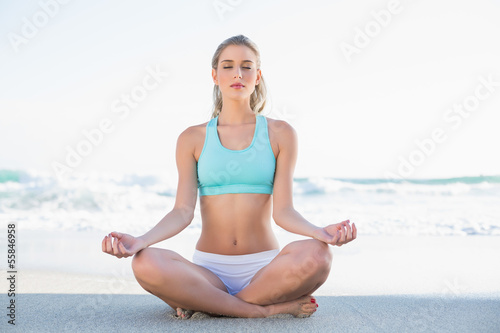 Relaxed slender blonde in sportswear meditating