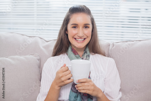 Cheerful pretty model holding cup of coffee