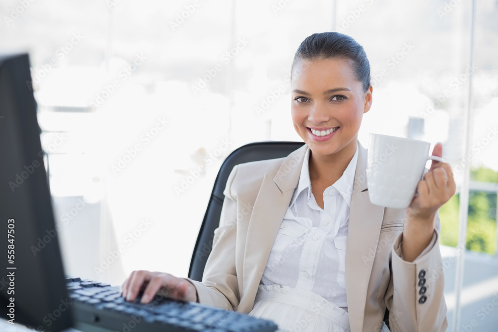 Smiling sophisticated businesswoman holding coffee