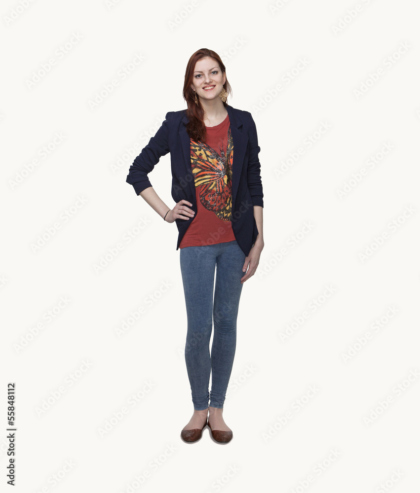 Portrait of smiling young woman in casual clothing, hand on hip, full length, studio shot Portrait of smiling young woman in casual clothing, hand on hip, full length, studio shot