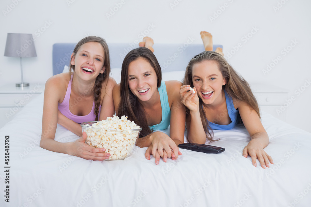 Friends eating popcorn and watching tv