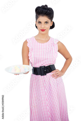 Attractive black hair model presenting a plate of candies