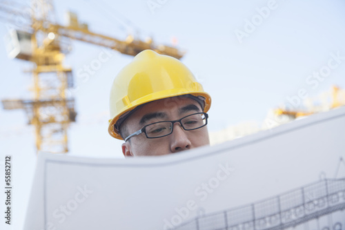 Photography Architect looking at blueprint