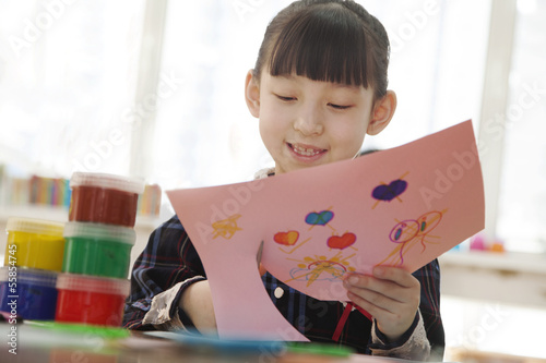 Schoolgirl cutting out drawing in class, Beijing 