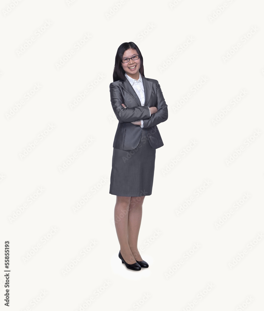 Portrait of smiling young businesswoman with arms crossed, studio shot, full length Portrait of smiling young businesswoman with arms crossed, studio shot, full length