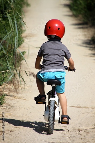 petit garçon faisant du vélo sur un sentier photo