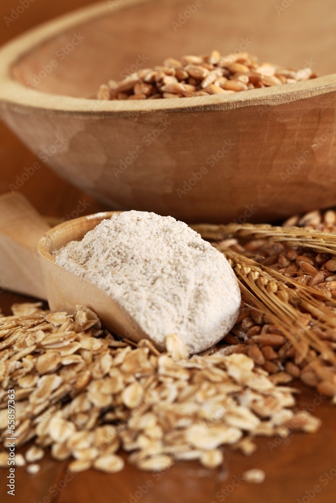 Wholegrain flour on wooden spoons, oats and corn Wholegrain flour on wooden spoons, oats and corn