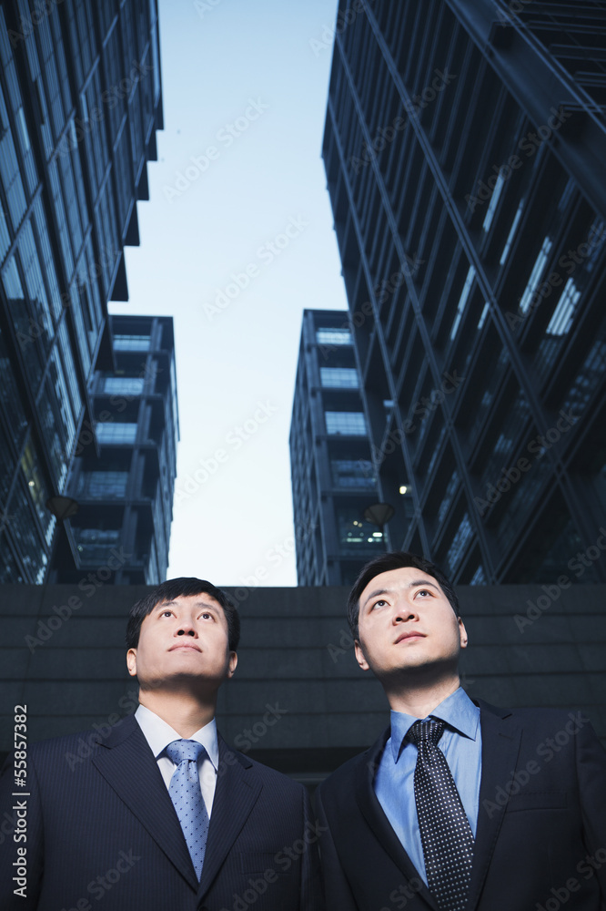 Two businessmen standing side by side outdoors, Beijing Two businessmen standing side by side outdoors, Beijing
