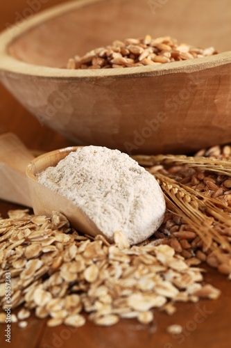 Wholegrain flour on wooden spoons, oats and corn
