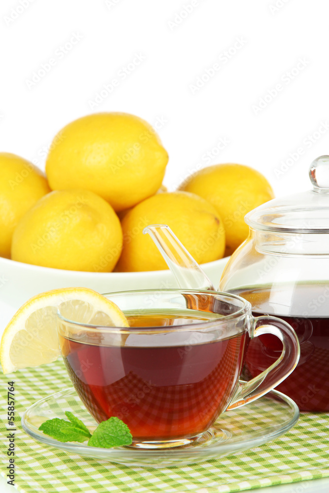 Cup of tea with lemon on table on white background