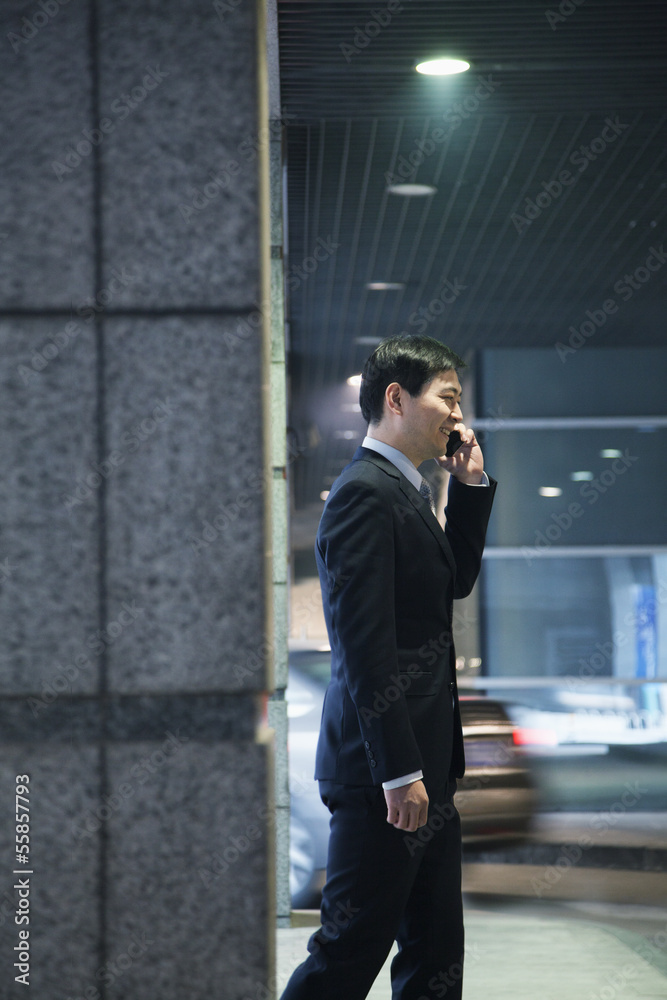 Businessman talking on the phone in a parking garage Businessman talking on the phone in a parking garage