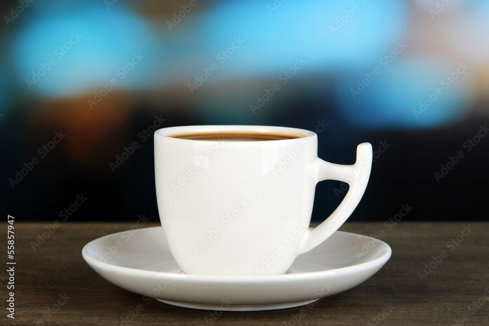 Cup of coffee on wooden table on bright background Cup of coffee on wooden table on bright background