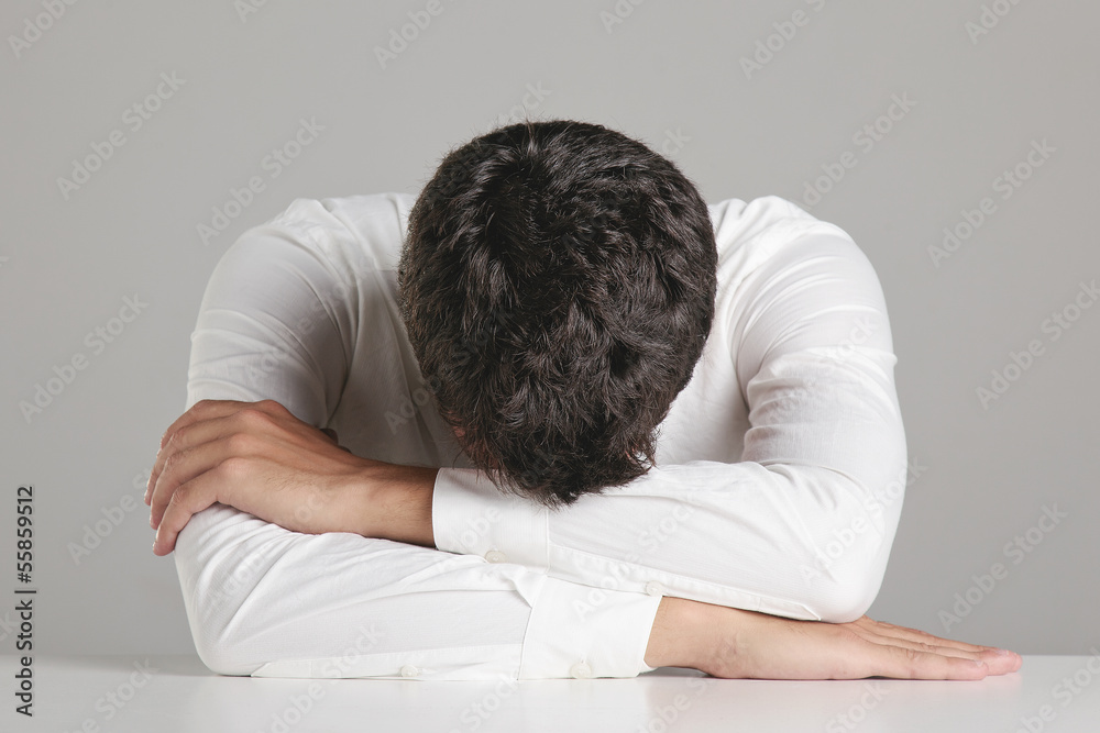 Portrait of a young businessman sleeping on desktop. Portrait of a young businessman sleeping on desktop.